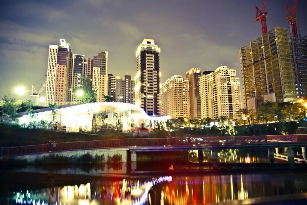 Autumn Red Valley: Urban Oasis by Day, Romantic Haven by Night Autumn Red Valley at night, with city lights reflecting on the water