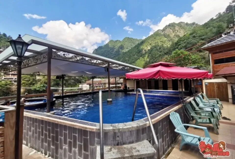 A tranquil hot spring pool nestled in a lush, green mountain valley.