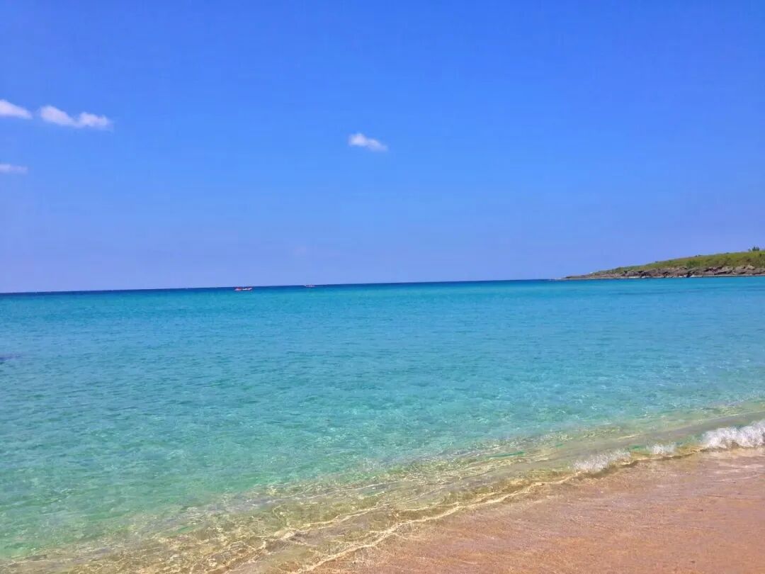 Clear turquoise ocean water at Baishawan Beach, revealing the sandy bottom