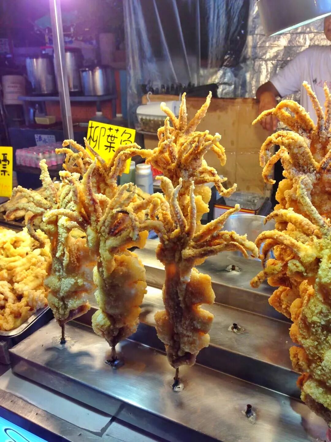 Street food vendors preparing and serving various local delicacies at night