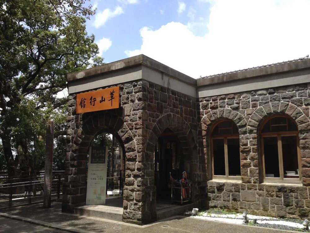 The distinctive main building entrance of Grass Mountain Chateau, featuring stone walls and warm wood