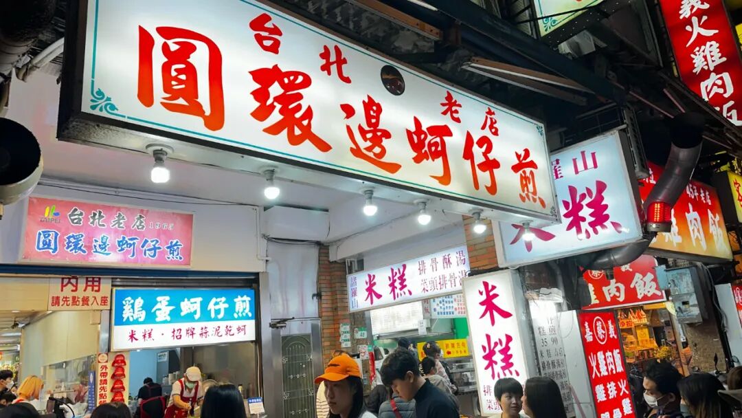 Cooking up a delicious oyster omelet at Ningxia Night Market Close-up of a sizzling oyster omelet on a large griddle at Yuan Huan Bian