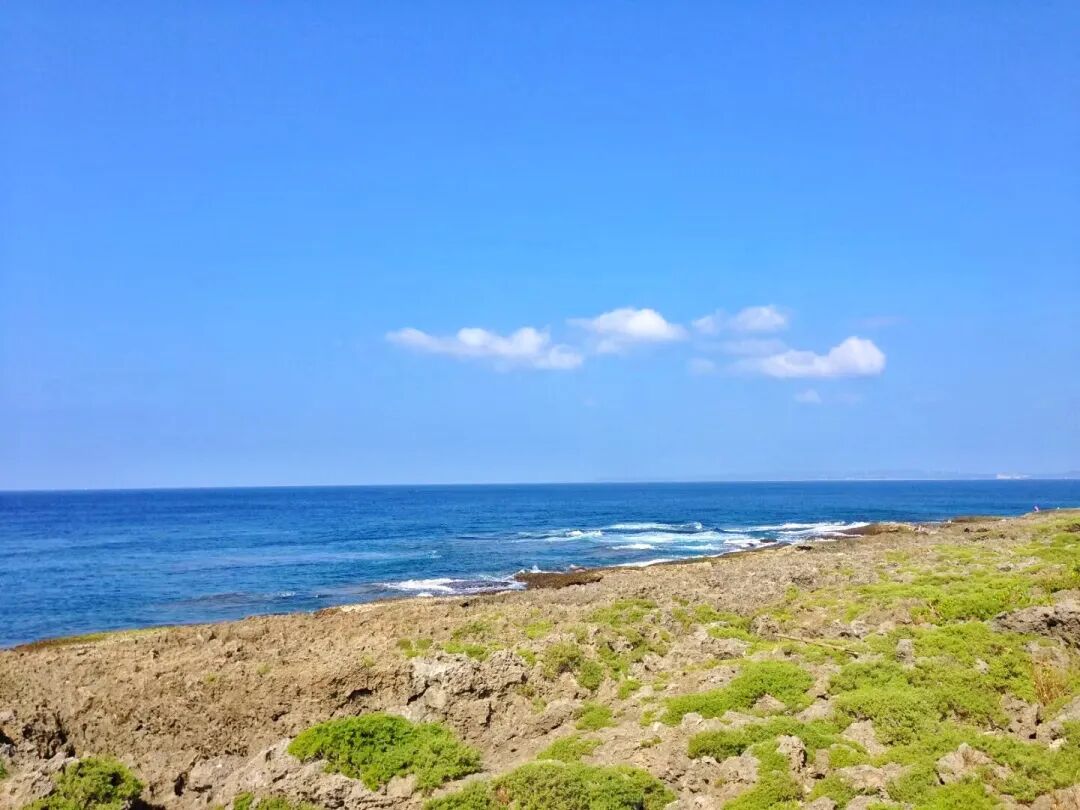 Clear blue waters of Kenting meeting a rocky coastline under a bright sky
