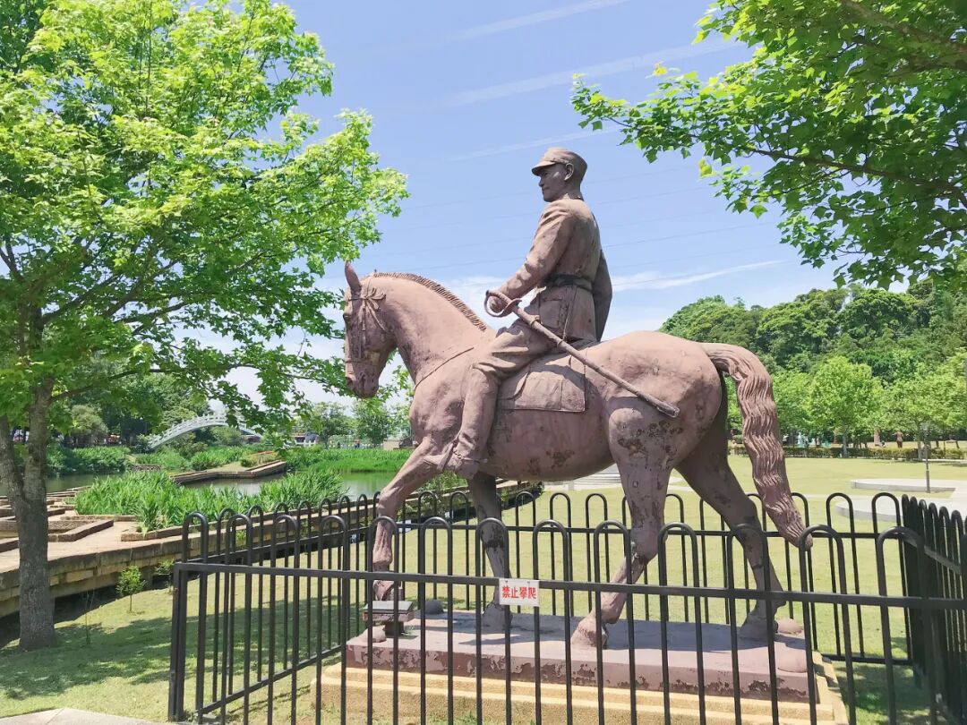 Another perspective of the Cihu Statue Park, featuring multiple statues amidst a beautifully maintained, lush garden.