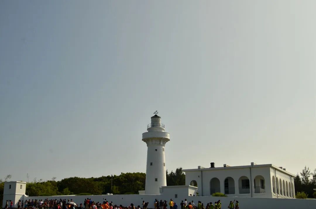 The iconic white and red Eluanbi Lighthouse standing tall against a blue sky