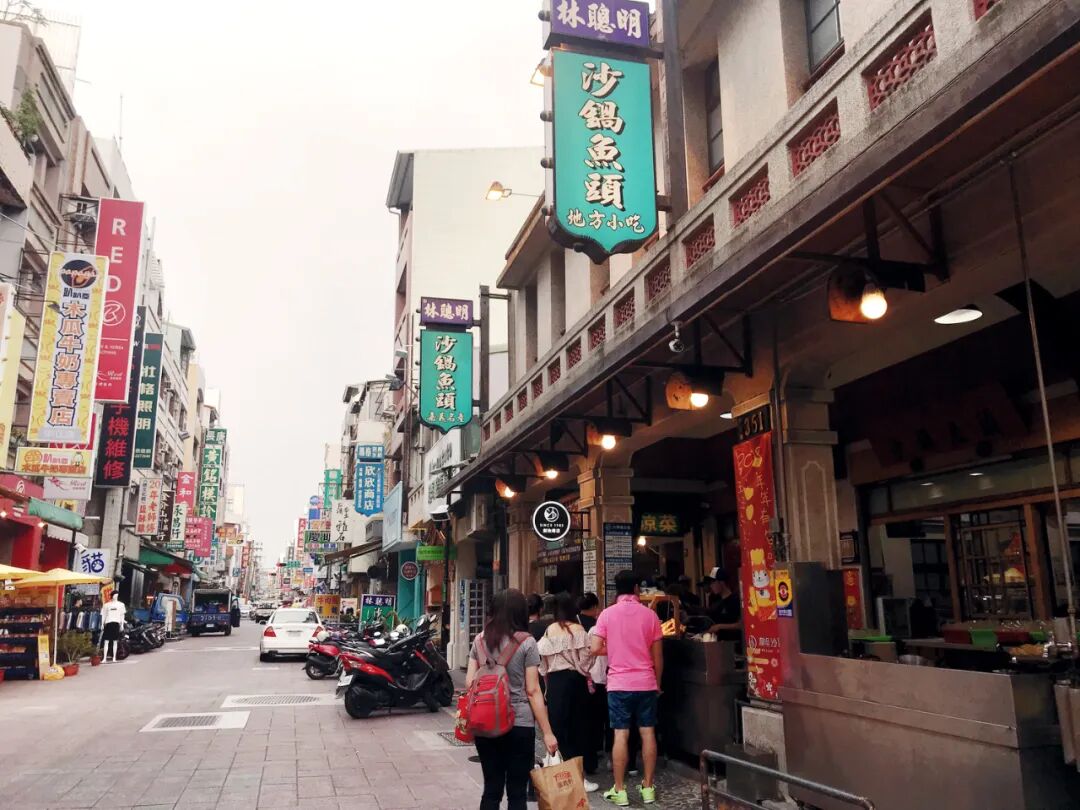 Aerial view of Chiayi's Wenhua Road Night Market, vibrant with people and food stalls at night.