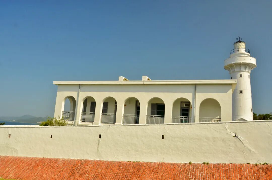 View of the Eluanbi Lighthouse from a distance, surrounded by green foliage
