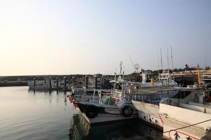 Wuqi Port: Epic Sunset Cruises A boat cruising at sunset near Wuqi Port, with a vibrant sky