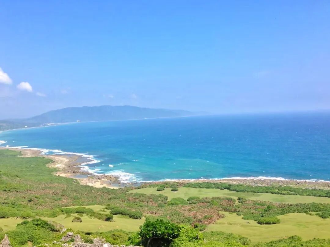 Longpan Park's dramatic cliffs and expansive green plains overlooking the Pacific Ocean