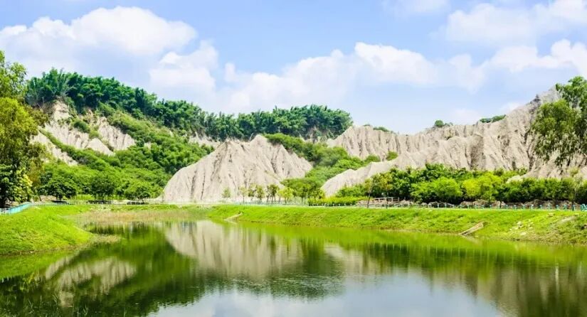 Scenic view of Tianliao Moon World's unique badlands landscape and lake