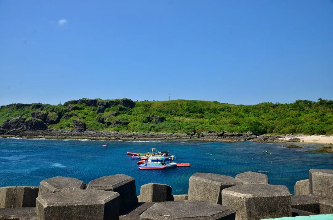 A person enjoying paddleboarding on the calm, clear waters of Houbihu Harbor