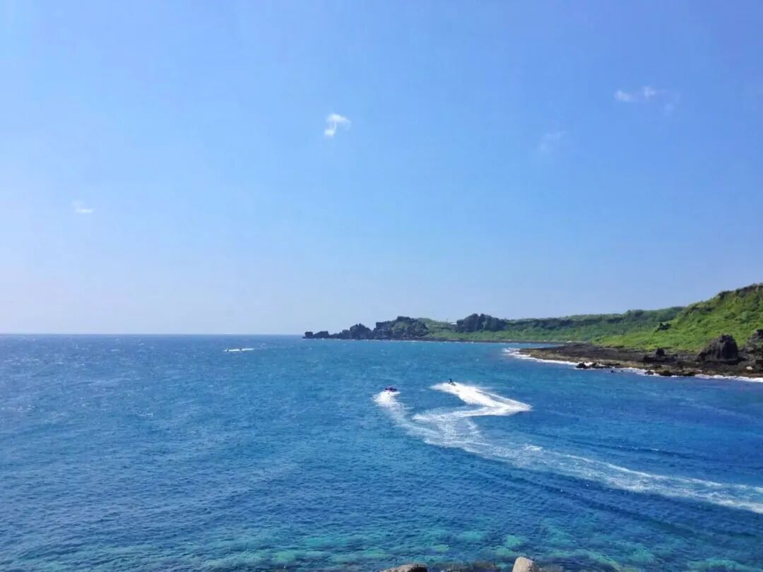 Fishing boats docked in the calm, clear waters of Houbihu Fishing Harbor
