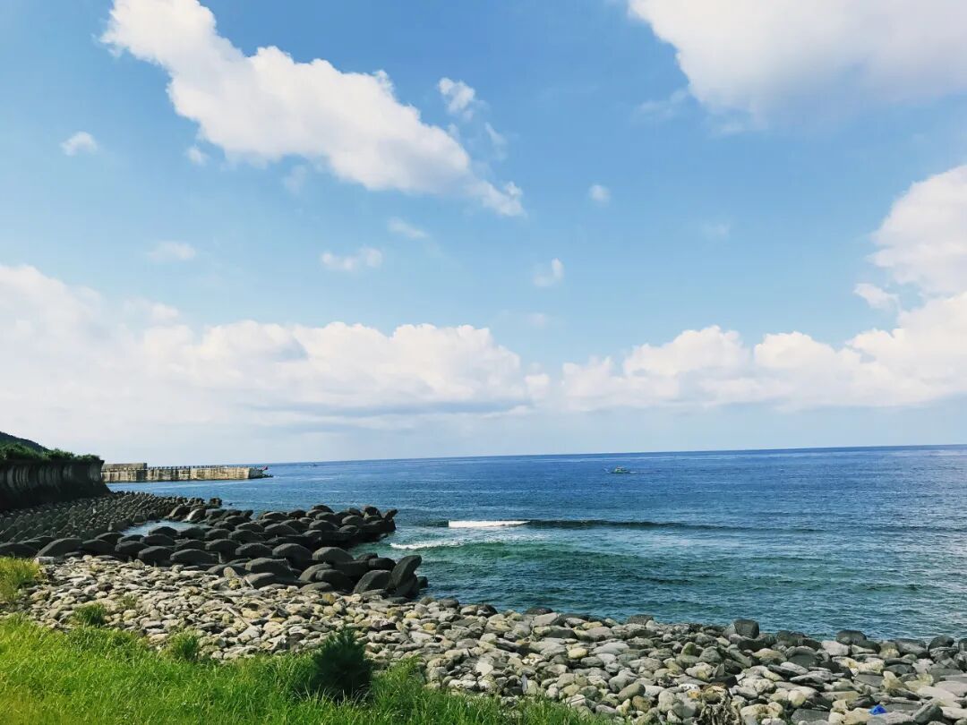 White Green Island Lighthouse against a clear blue sky, overlooking the ocean.